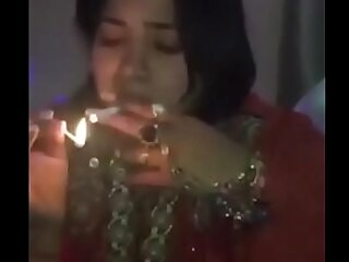 Indian girl flirts and smokes, getting wild and horny, indulging in a steamy encounter.